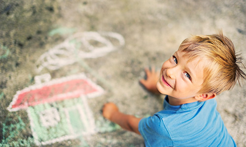 Boy Drawing with Sidewalk Chalk